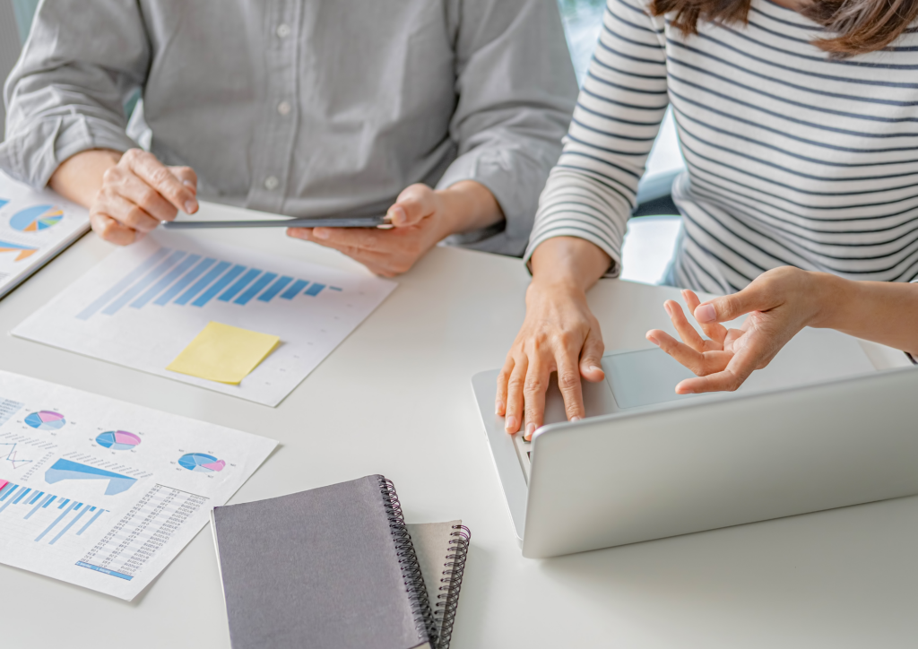 A stock photo of two people working at a laptop and consu